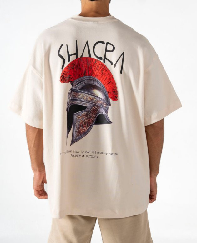 Vivid graphic t-shirt featuring a Roman helmet with a red crest and the word “SHACR” in bold letters, showcasing modern streetwear fashion and artistic design.