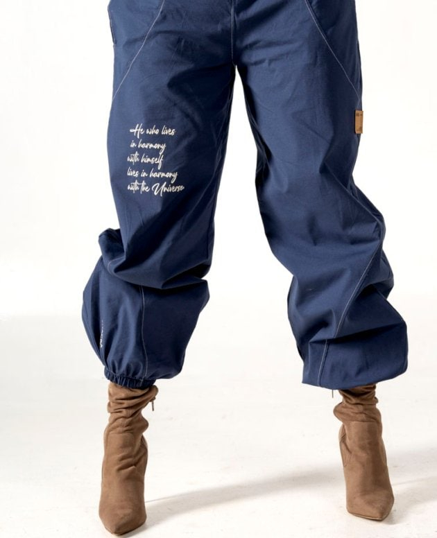 Relaxed fit navy blue cargo pants with inspirational embroidery, elastic waistband, and ankle cuffs, perfect for casual wear or street style outfits.